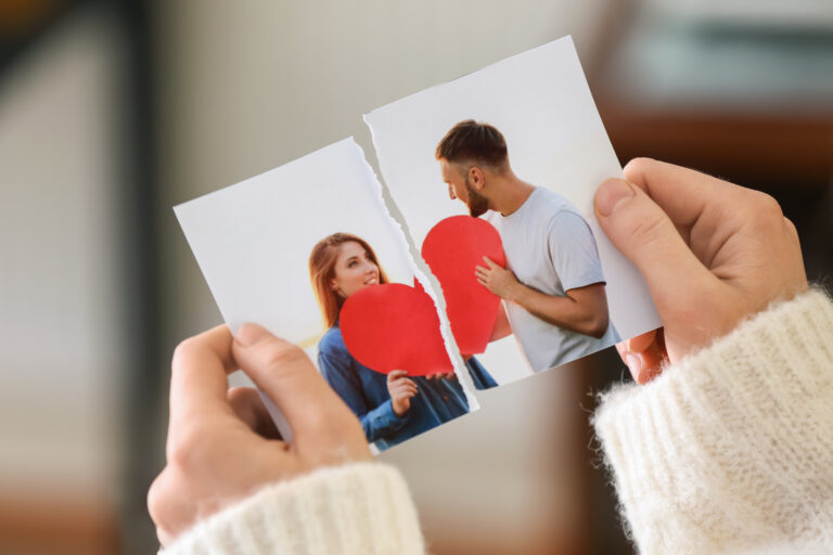 Woman tearing up photo of happy couple, closeup