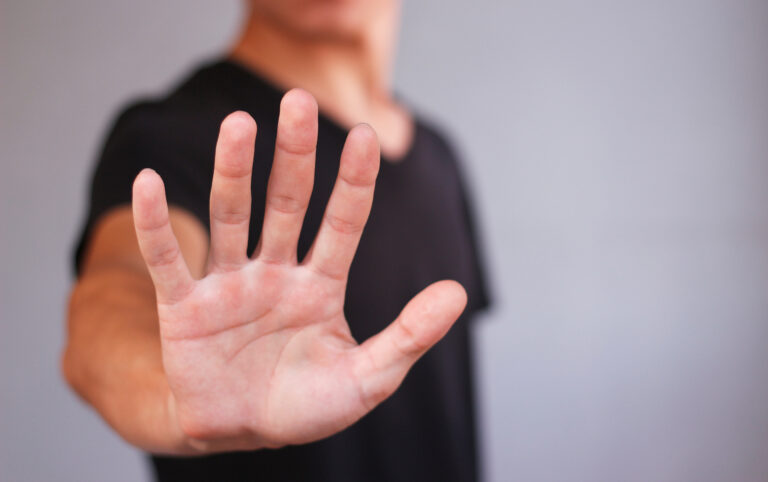 Young man in black t shirt shows his hand