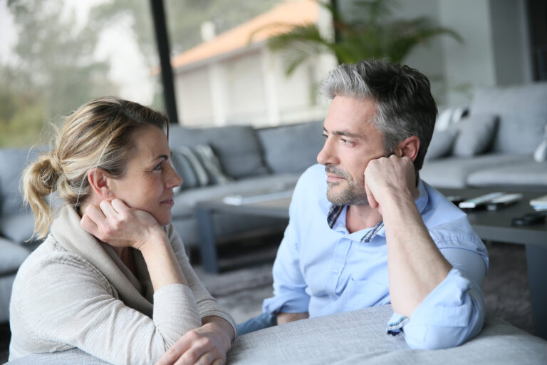 Mature couple talking to each other in sofa